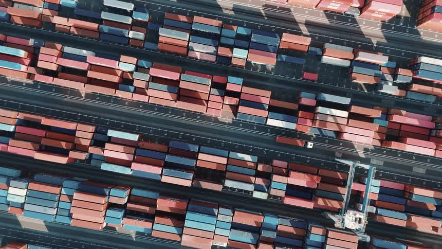 Aerial view of a port area where several trucks are moving containers