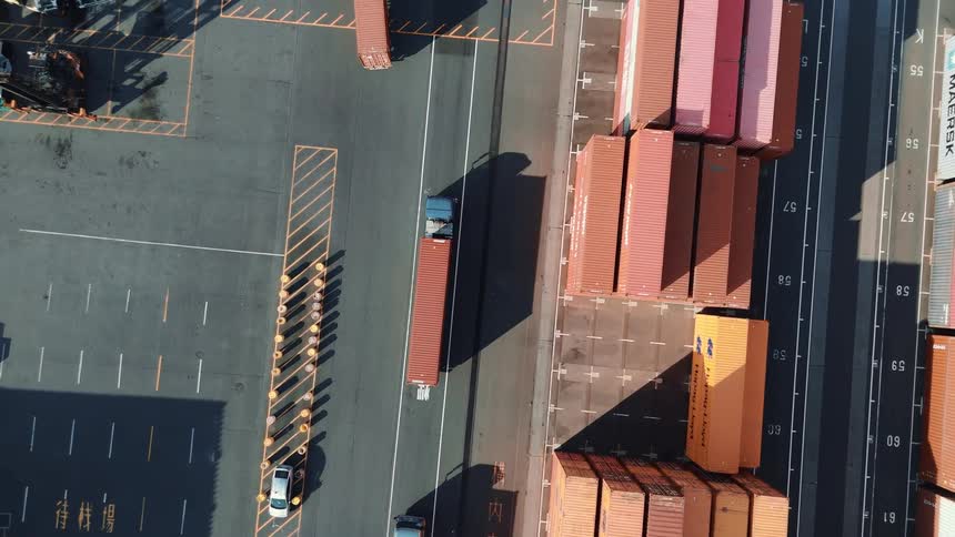 Aerial view of stacked containers and trucks operating in a port terminal