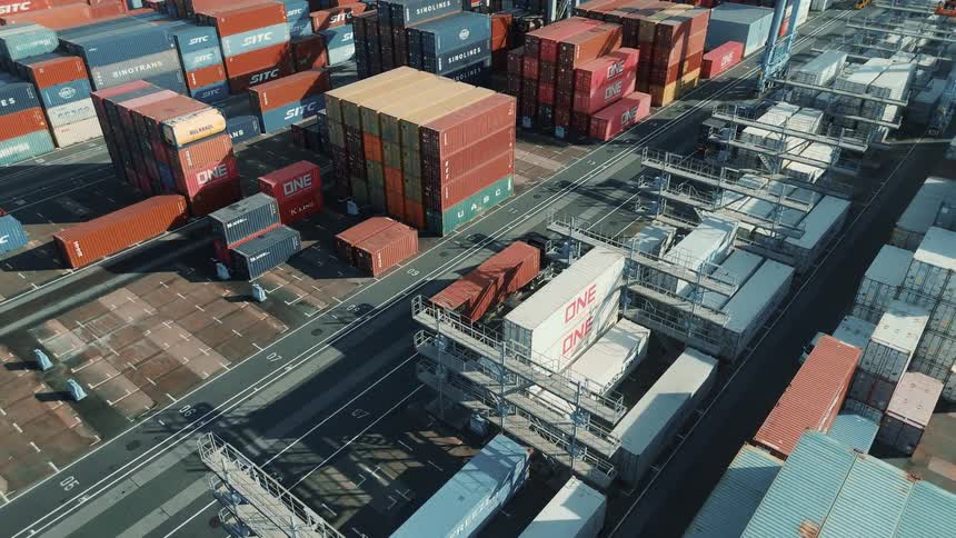 Drone view of a port area where trucks are transporting some containers