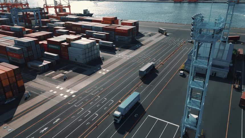 Trucks moving through a port with stacked containers