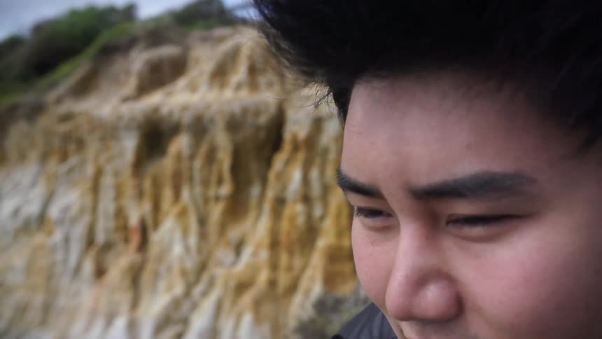 Man smiling and enjoying the scenery as the wind blows through his hair