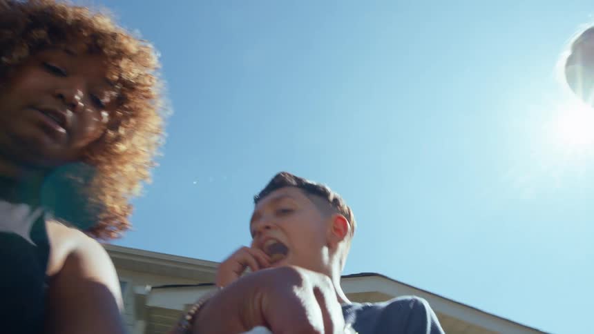 A group of teenagers and an adult stand outside and grab something to eat