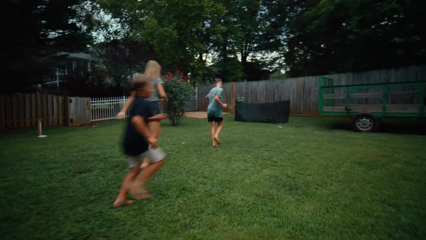 Children have fun running through the sprinkler water