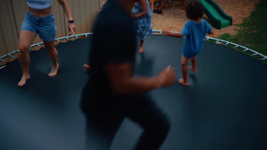A family is jumping together on the trampoline