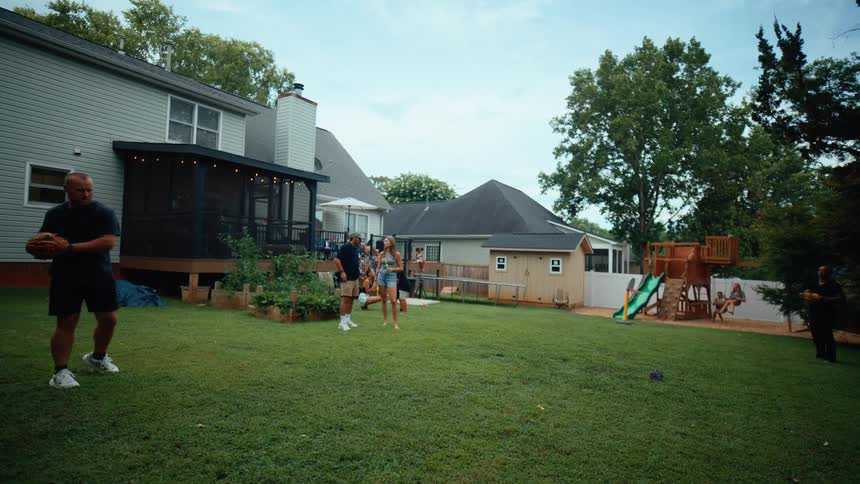Family and friends hangout in the backyard during a get together on a summer day