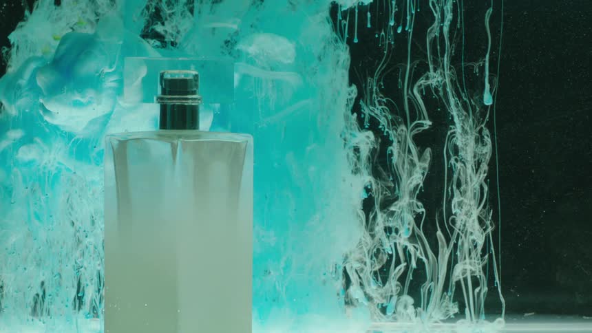 Smoke falls down on the perfume bottle