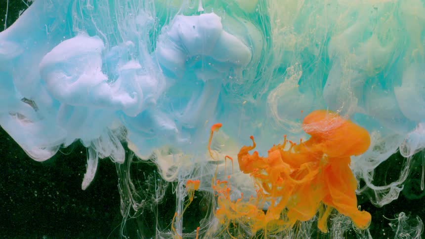 In this video blue and yellow ink slowly dissolve and swirl in a tank of water creating beautiful abstract patterns the vibrant orange ink is added adding a pop of color that mixes with the other shades