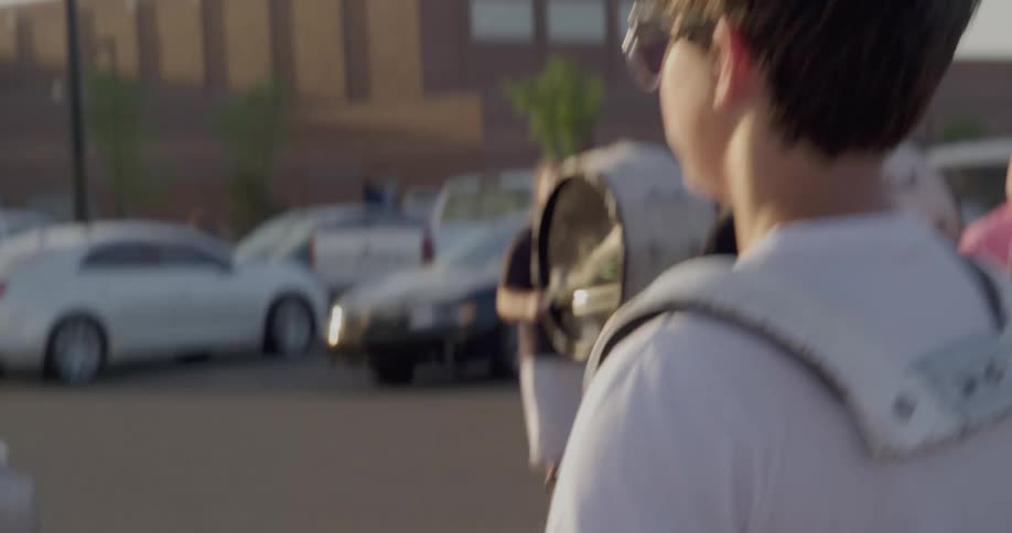 A band are playing drums in the parking lot