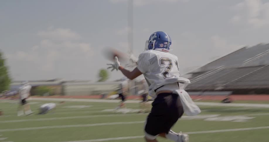 The football player catches the ball during practice