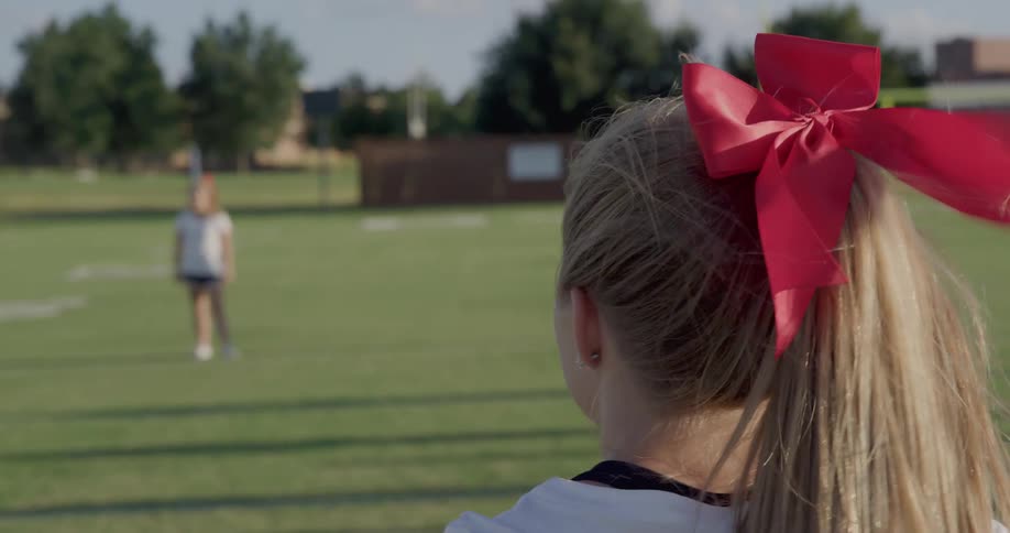 Female teenagers train on a football field on a windy day