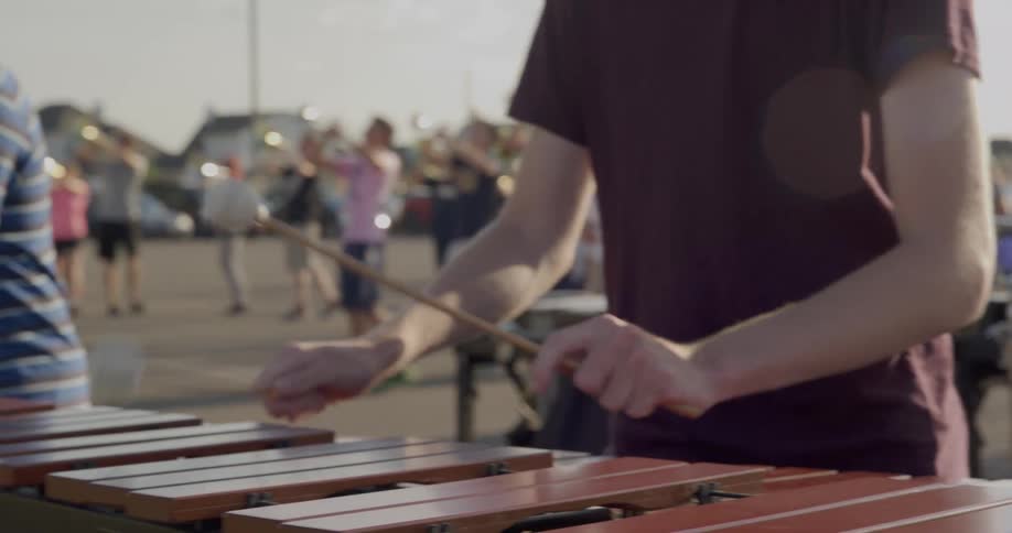 Teenagers play music instruments outside together
