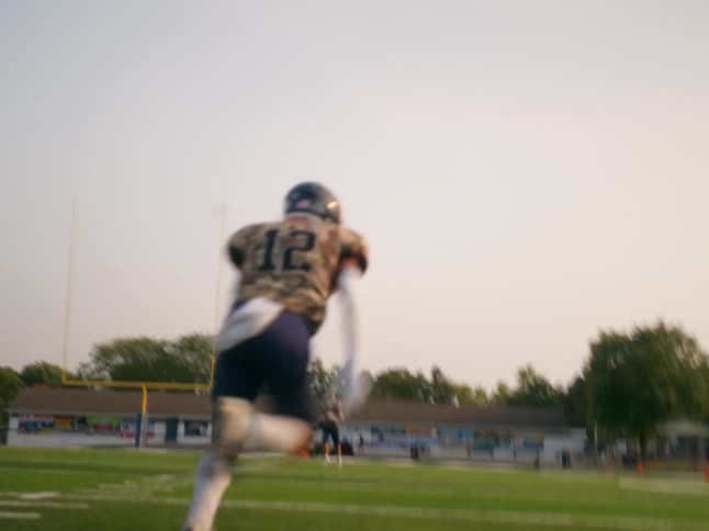 A football player runs down the field with intense camera shakes