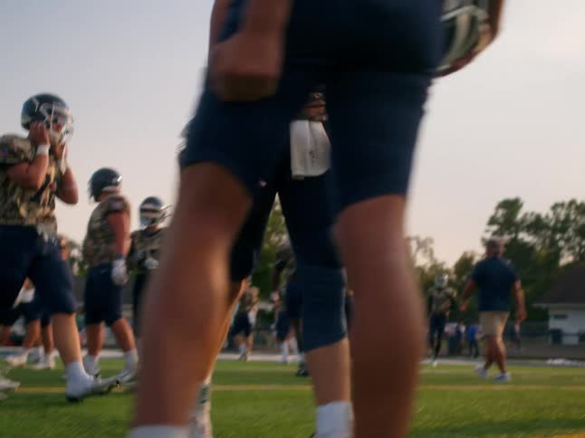 High school football players practicing on field low angle shot