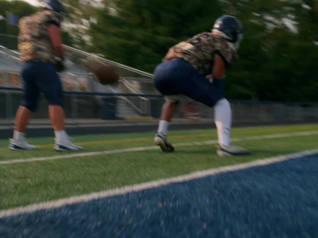 Player throwing a ball backwards in an american football training session