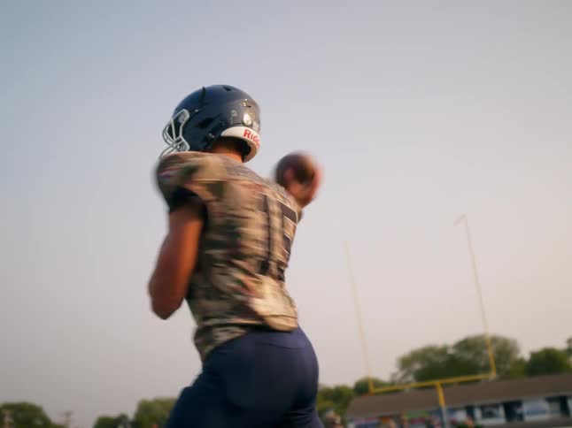Football quarterback winds up and throws a football