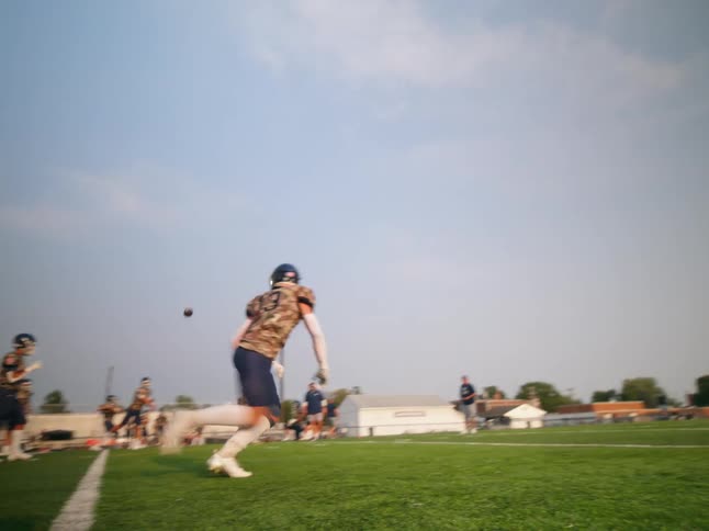 Player dropping and catching a ball in an american football training session