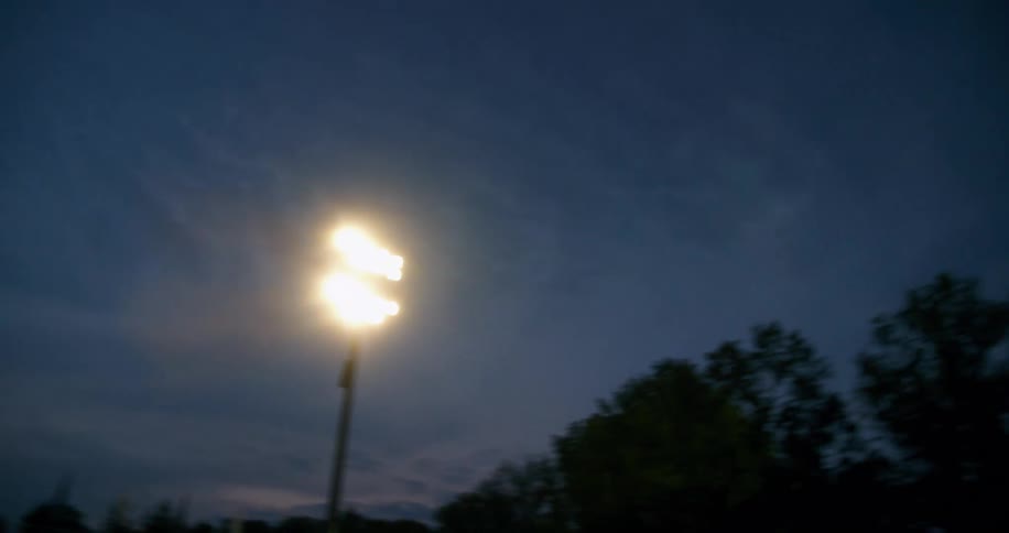 A bright stadium light shines over a stadium