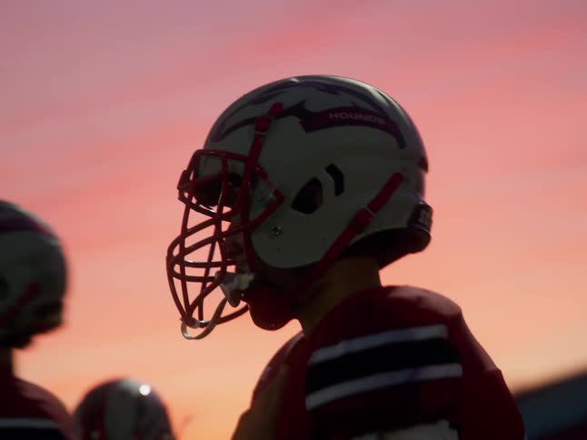 Undercranked footage of American football player helmet at sunset