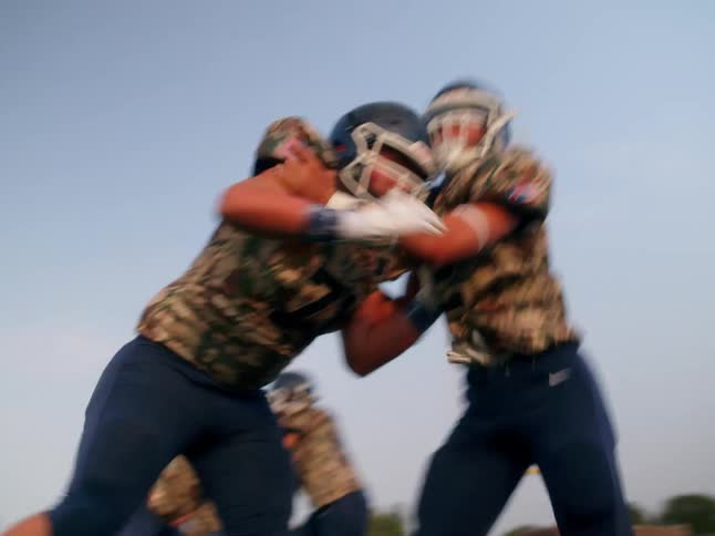 American football linemen clash and block in a match