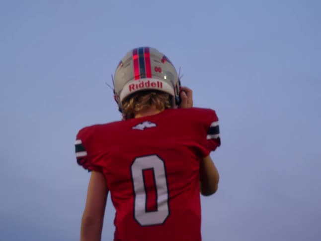 The video shows two distinct lines of football players in uniforms in the foreground a player in a red jersey with the number 0 on the back is standing with his back to the camera getting ready for a drill in the background there is a line of oth
