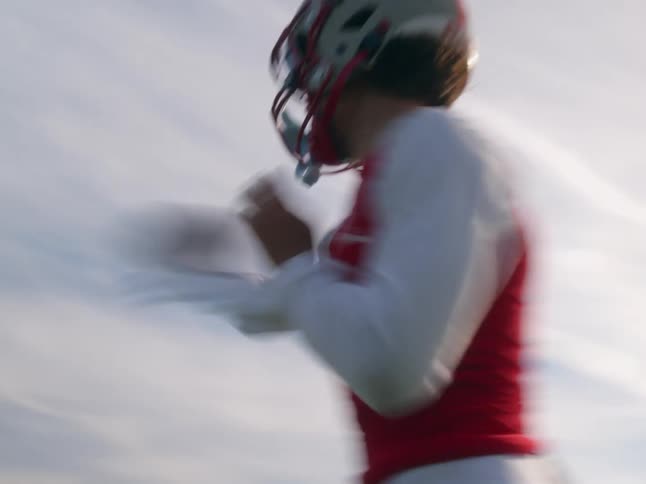 The quarterback winds back and throws the football