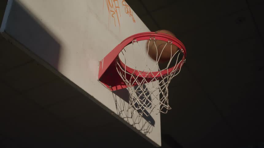 A basketball falls through a basketball hoop without touching the rim