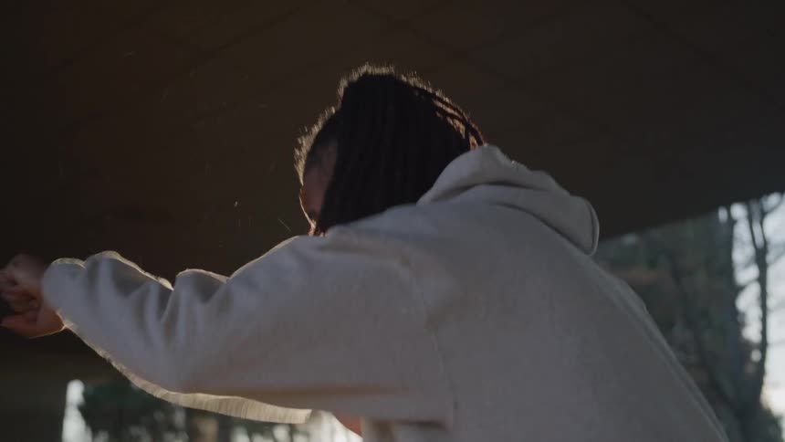 Man under an overpass training by punching the air