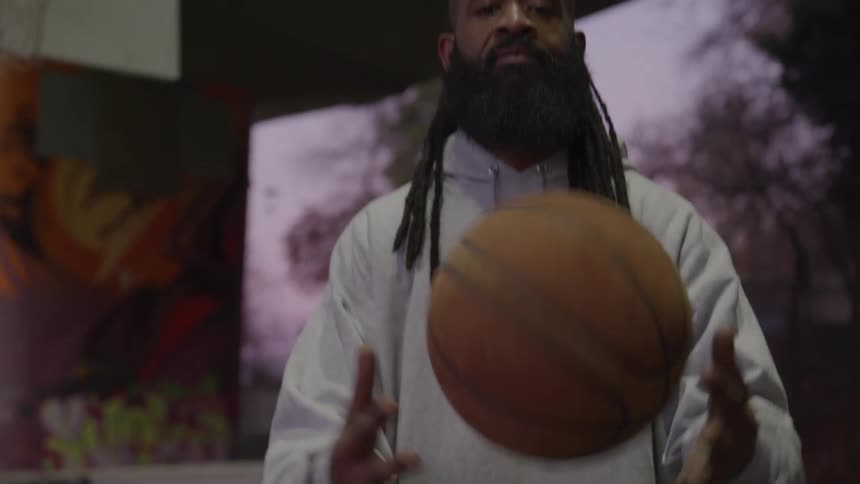 The man spins the basketball around his waist