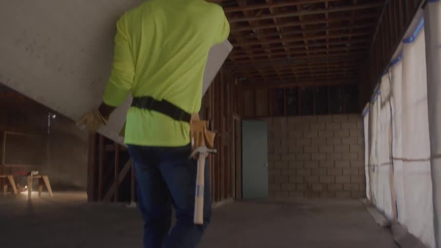 Man walking with a sheet of drywall