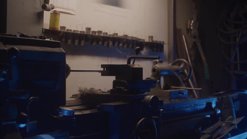 Lit workshop bench with a lathe and organized tools