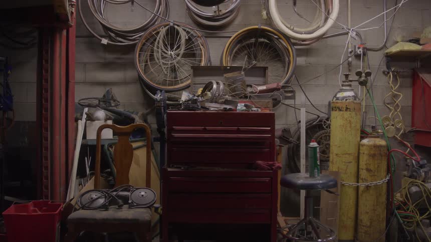 Workshop with bicycle wheels hanging on the wall and tools scattered around