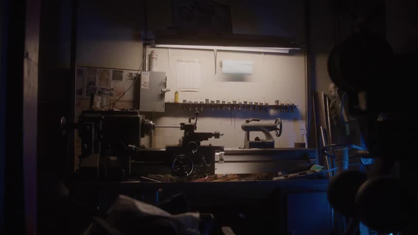 Workbench inside a garage with a series of tools lying on its surface