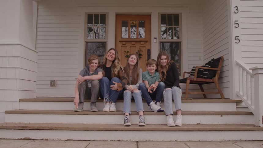 Family gathered sitting on the porch steps