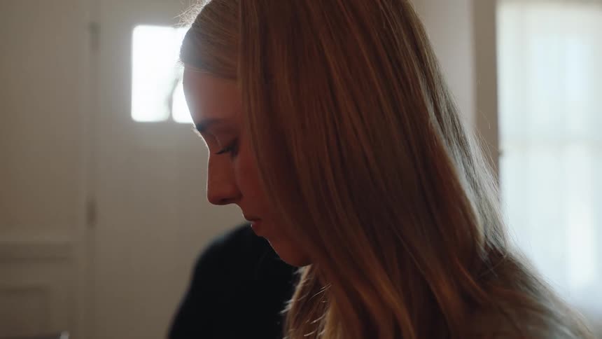 Closeup of a young person in standing indoors with soft natural light behind