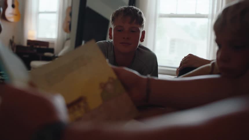 A family sits at a table listening closely to a storytelling session