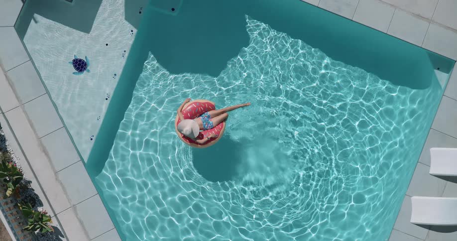 Woman lying in a floating ring float kicks their feet on a summer day