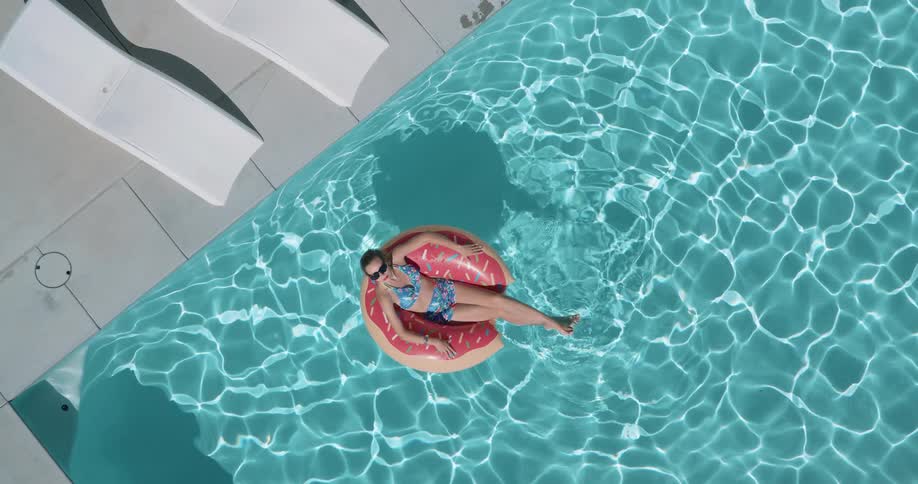 Woman lying in a pool ring float looks around