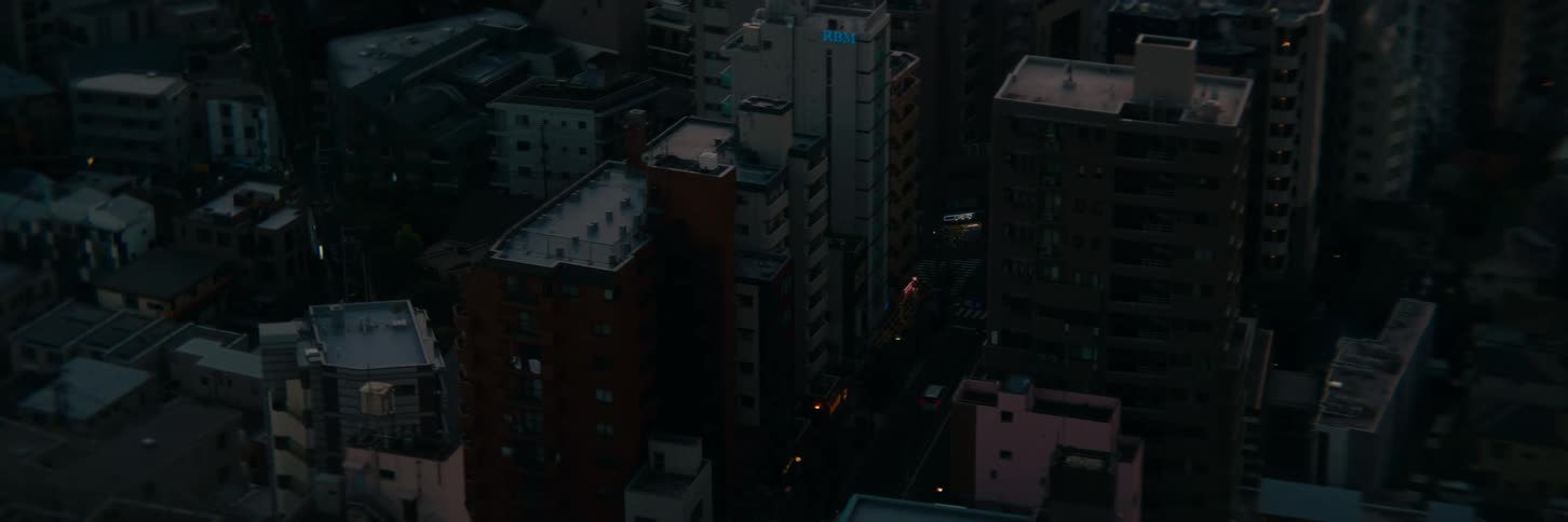 Tall buildings and narrow streets are softly lit at dusk