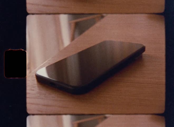 Black smartphone resting on a wooden table