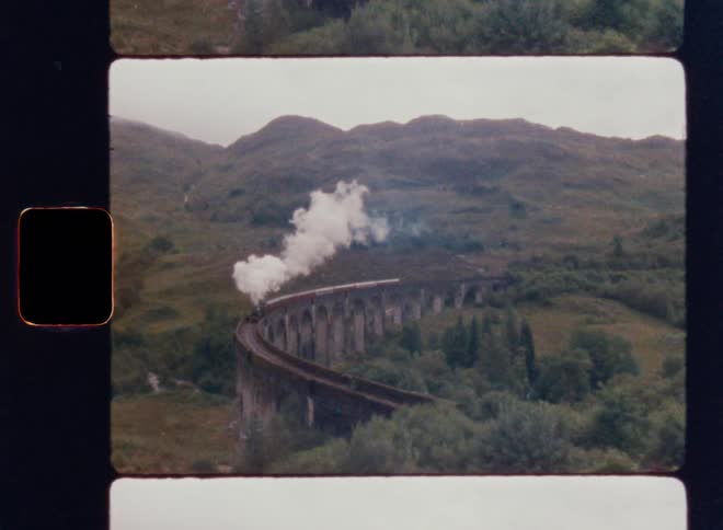 Smoke rises from the moving train through the mountains