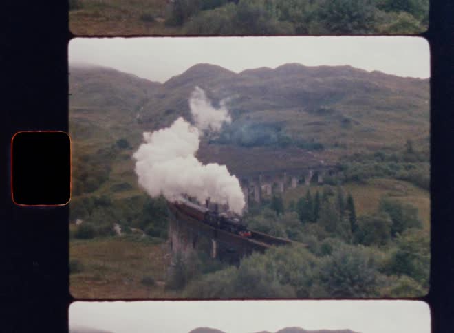 Steam train crossing a bridge in the mountains