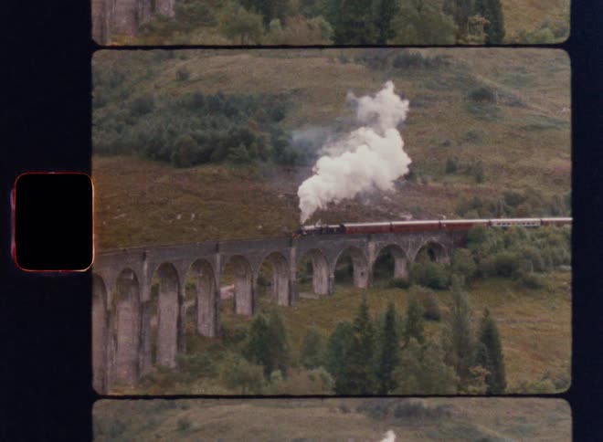 The train travels over the green hills