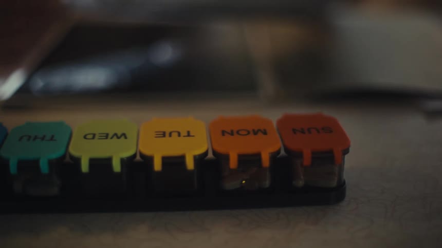 A colorful pill organizer is on the table
