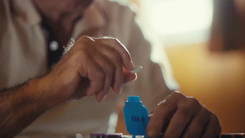 The man puts the pill into the container
