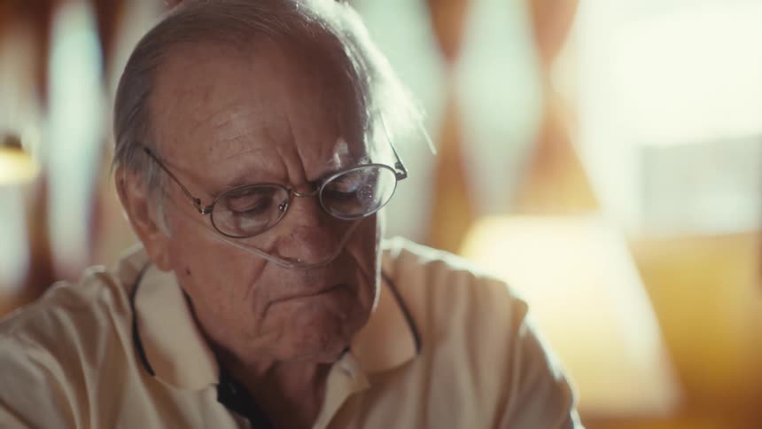 The man removes a pill and examines it