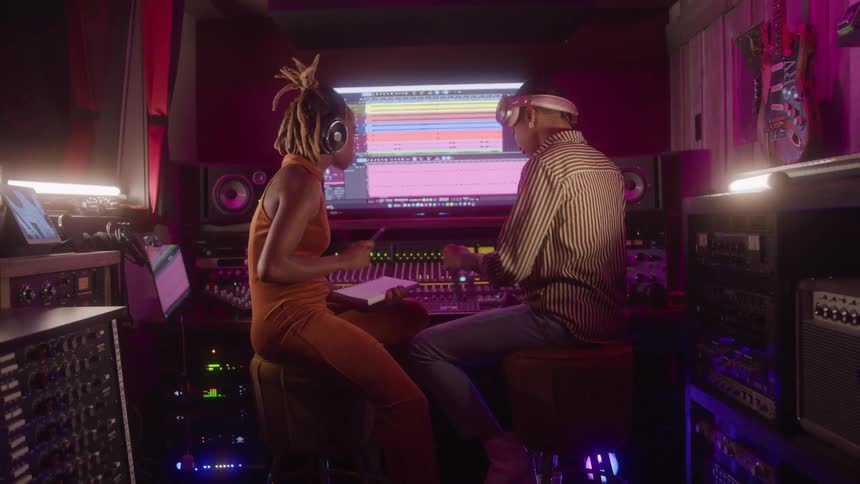 The man and woman are making music in the studio
