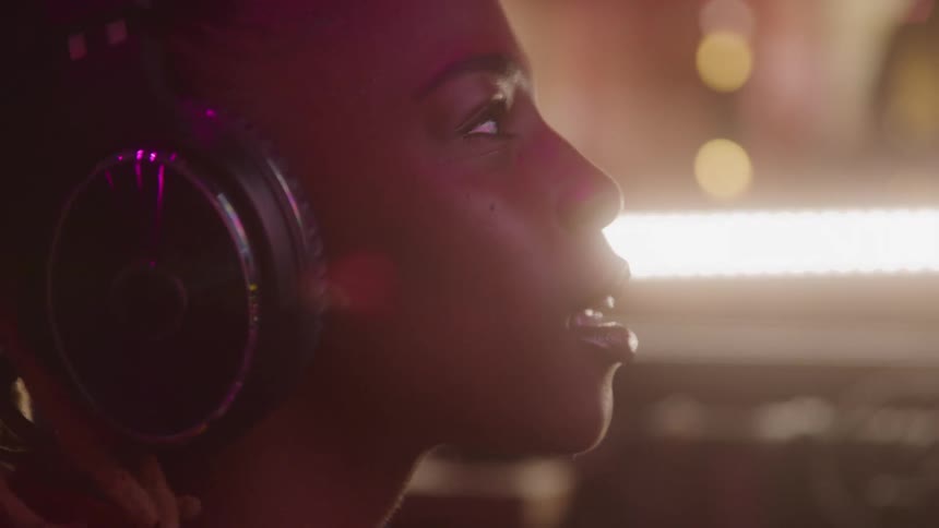 The woman nods her head while listening to music on headphones