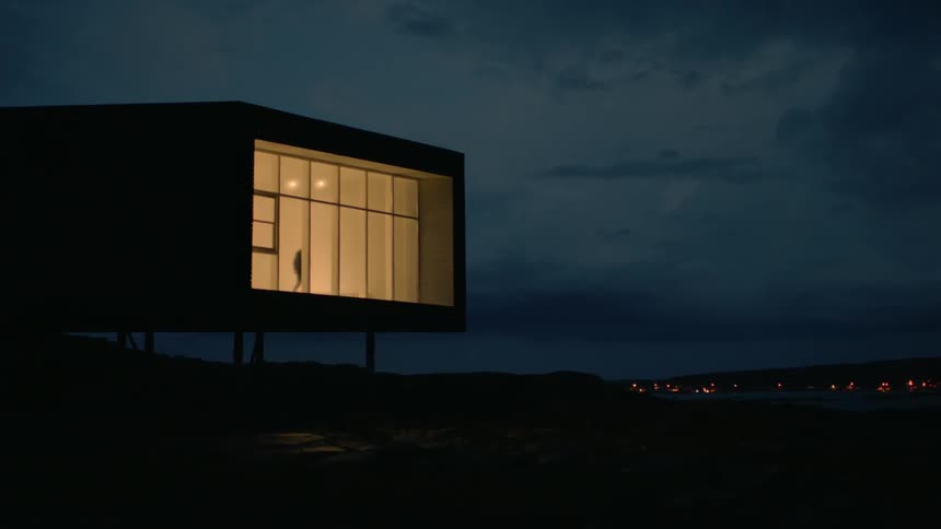 A man walks in front of a wall of windows