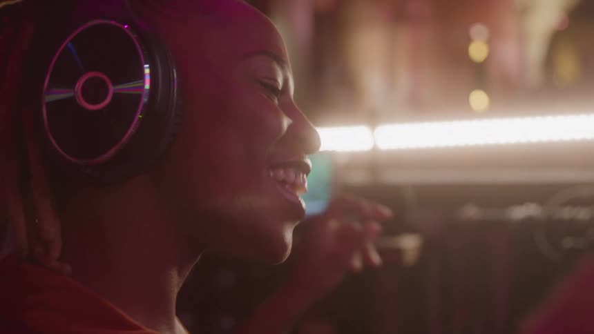Young woman wearing a headset dancing to the song shes listening to