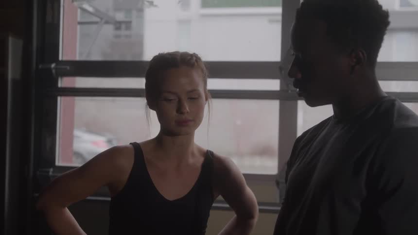 Personal trainer talks with a trainee during a workout at the gym
